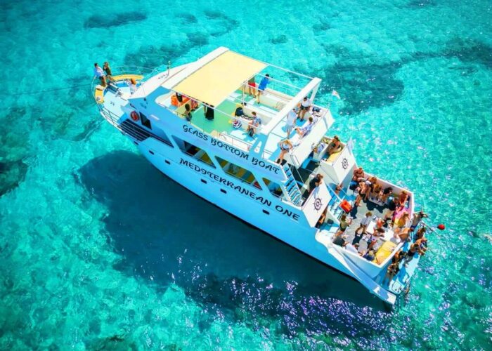 Tourists boarding glass-bottom boat with waterslide, Blue Lagoon, Cyprus